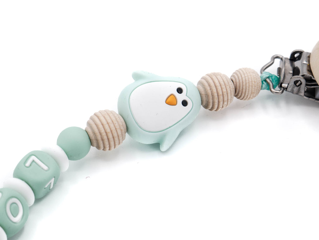 Handgefertigte und individuelle Schnullerkette mint Pinguin - Schnullerkettenwelt